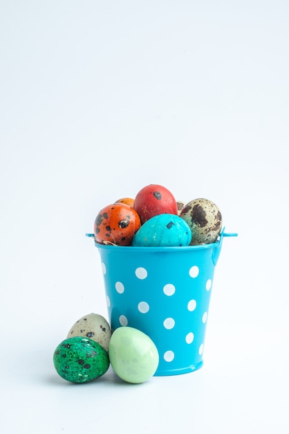 front view colored painted eggs inside blue basket on white background ornate spring colourful concept holidays novruz horizontal