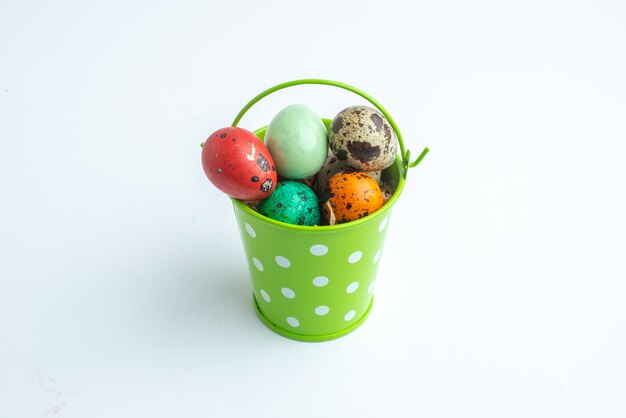 front view colored painted eggs inside green basket on white background spring colourful novruz concept ornate holiday