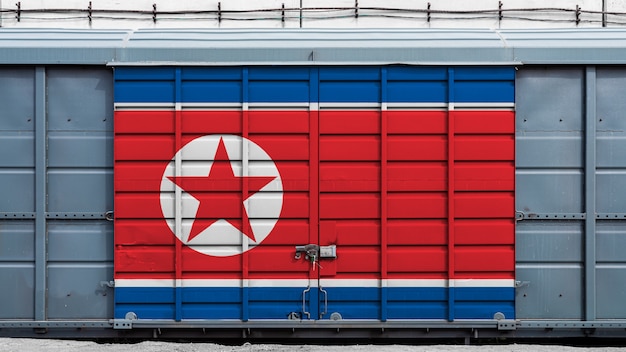 Photo front view of a container train freight car with a large metal lock with the national flag of north korea.