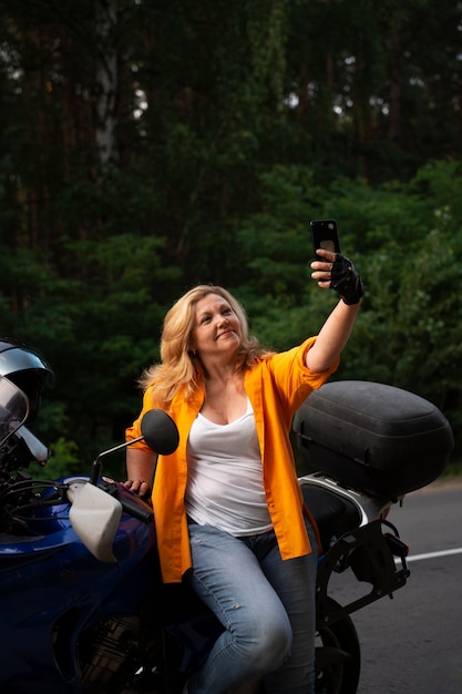 Photo front view cool old woman with motorbike