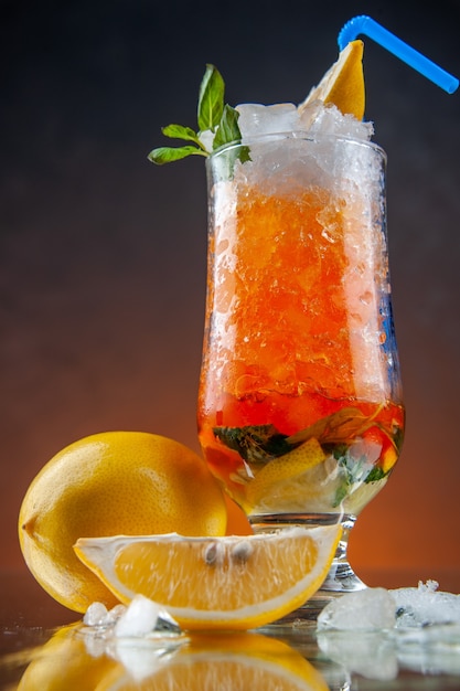 전면 보기 오렌지 배경에 레몬과 얼음을 넣은 시원한 오렌지 칵테일 차가운 음료 색상 레모네이드 바 주스