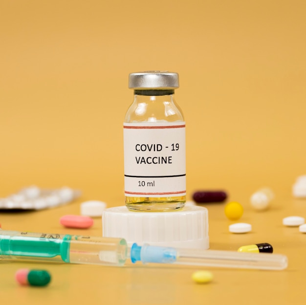 Photo front view of coronavirus vaccine with syringe