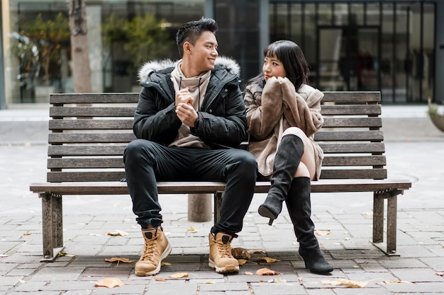 front view of couple sitting on a bench together