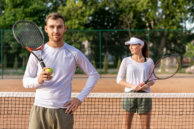Photo front view couple on tennis court