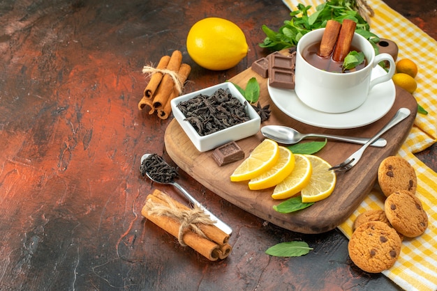 Photo front view cup of tea with chocolate and lemon slices on dark background fruit cocoa breakfast ceremony color sweet