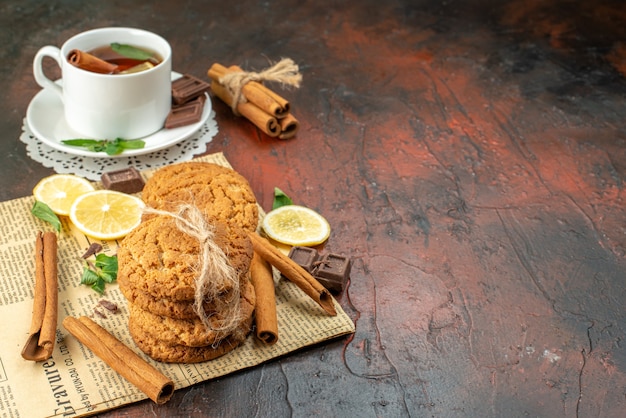 front view cup of tea with fresh yellow lemons and biscuits on dark background morning sweet ceremony breakfast fruit tea color