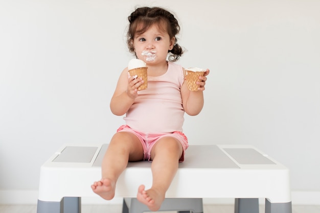 Front view cute young girl eating ice cream