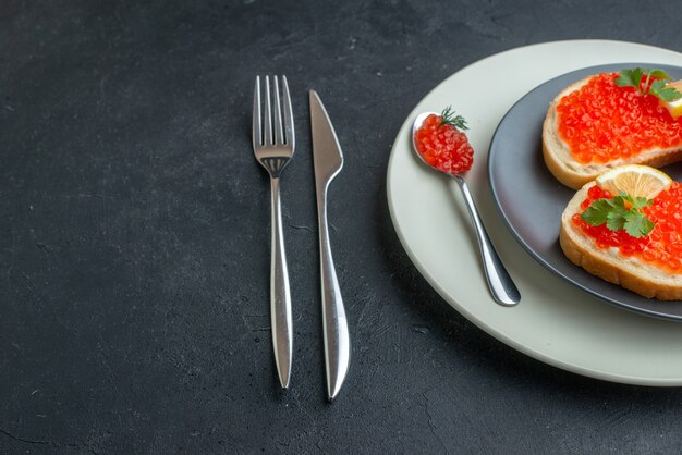 front view delicious caviar sandwiches inside plate with fork and knife on dark background snack toast fish bread dinner dish food meal