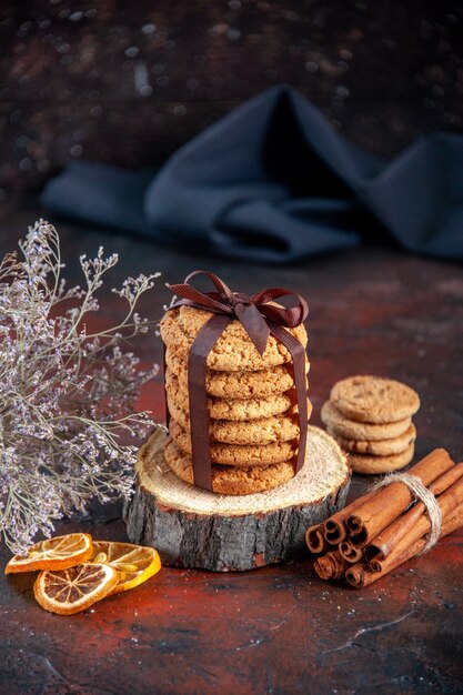 Vista frontale deliziosi biscotti dolci legati con fiocco su sfondo scuro torta di zucchero orizzontale torta biscotto