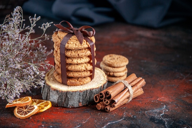 Vista frontale deliziosi biscotti dolci legati con fiocco su sfondo scuro torta di tè orizzontale torta biscotto