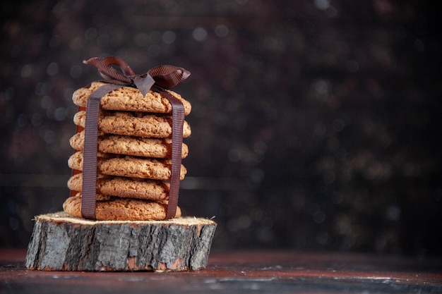 Front view delicious sweet cookies tied with bow on dark background sugar dessert tea biscuit sweet