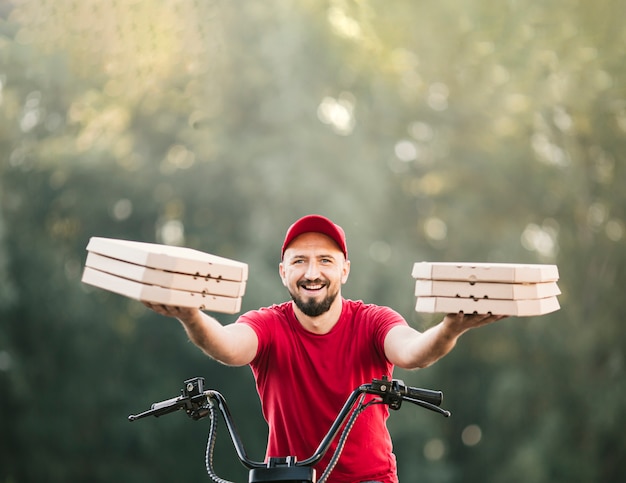 Front view delivery guy holding pizza boxes