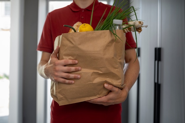 写真 食料品を保持している正面図の配達人