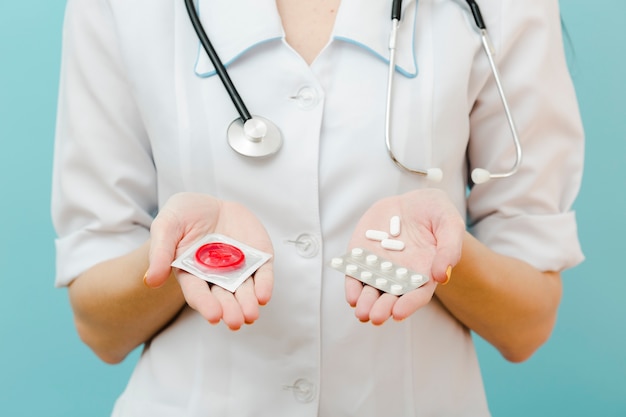 Photo front view doctor holding contraception options