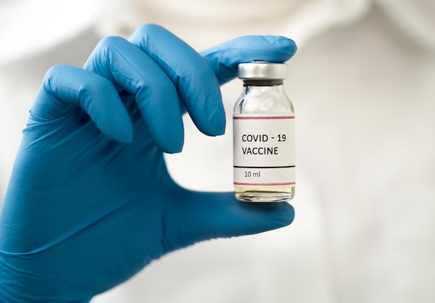 Photo front view of doctor holding coronavirus vaccine