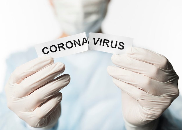 Front view of doctor holding torn paper with coronavirus