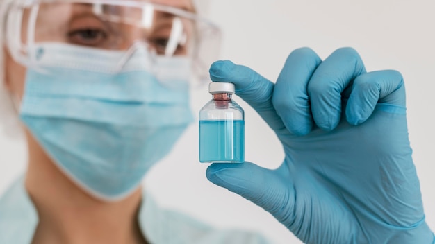 Front view of doctor with gloves holding vaccine