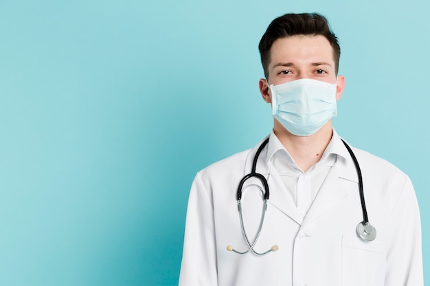 Photo front view of doctor with medical mask and stethoscope