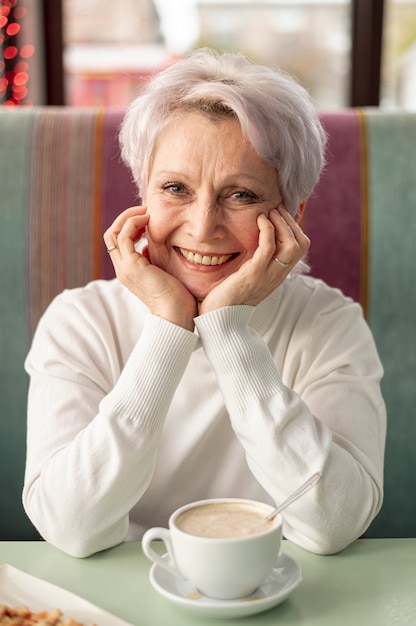 Front view elder smiley woman at restaurant