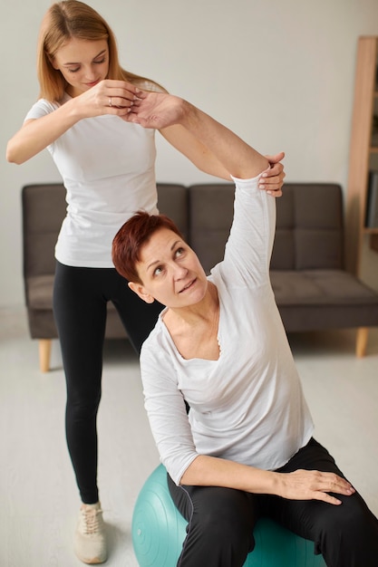 Photo front view of elder woman in covid recovery doing physical exercises