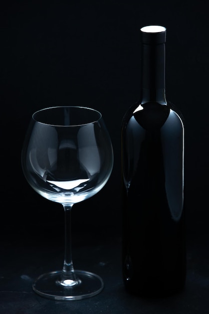 Front view empty wineglass with bottle of wine on a dark background color wine alcohol celebration holiday restaurant