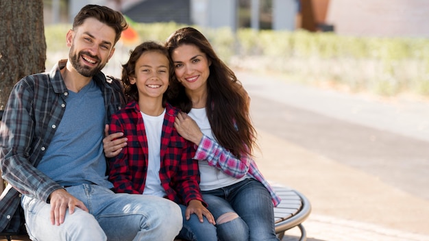 Foto vista frontale della famiglia con bambino e genitori all'aperto con copia spazio