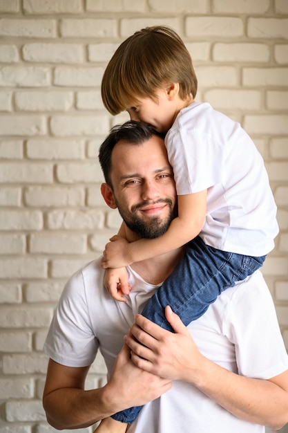 Foto padre di vista frontale che tiene il suo bambino