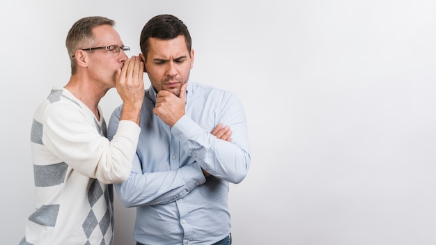 Photo front view of father whispering to son