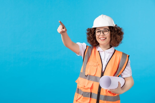 Front view of female builder in uniform blue wall