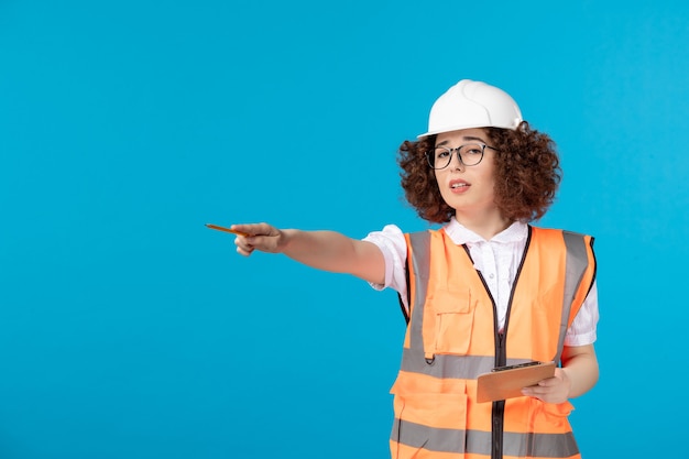 Front view female builder in uniform on a blue 