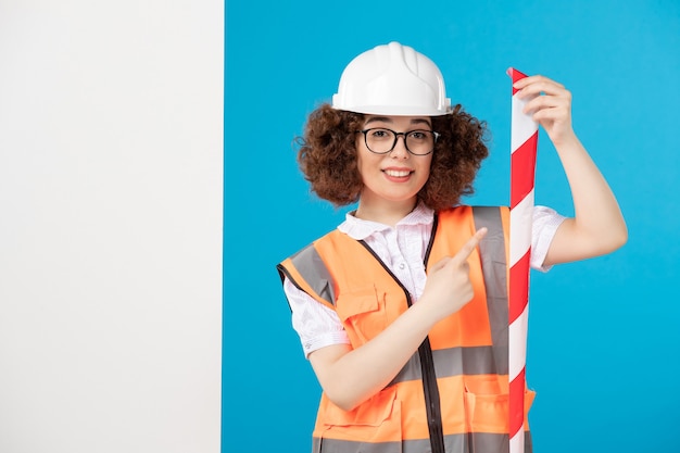 Front view female builder in uniform on blue 