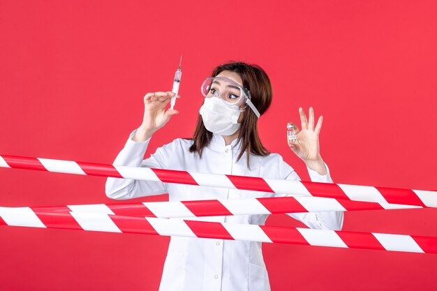 front view female doctor holding injection and flask on red background sealed crime covid- line hospital health virus medical