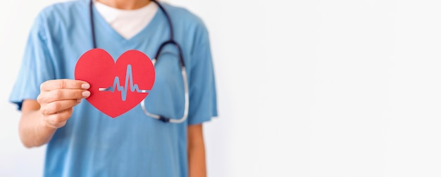 Front view of female doctor holding paper heart with copy space