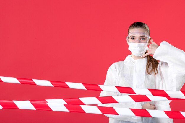 사진 전면 보기 여성 의사 보호복 및 빨간색 배경에 마스크 건강 라인 covid-cure 격리 범죄 위험 바이러스 병원