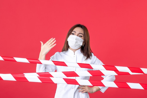 front view female doctor in medical uniform and mask on a red background sealed pandemic crime line covid- health virus hospital