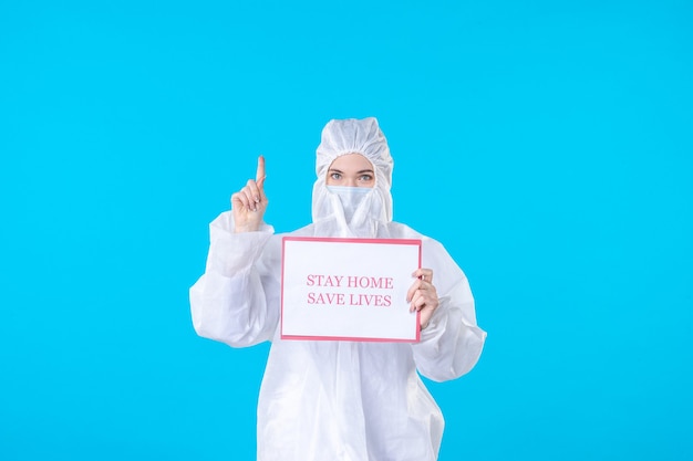 front view female doctor in protective suit holding stay home save lives on blue background science covid isolation pandemic virus medical