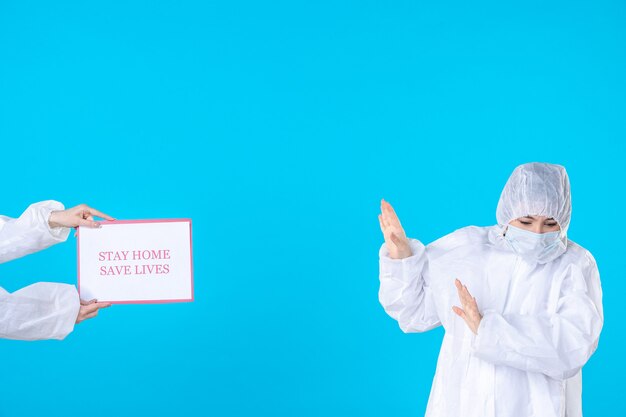 Front view female doctor in protective suit and mask on blue background isolation covid health virus medical disease pandemic