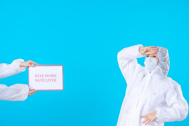 Foto vista frontale dottoressa in tuta protettiva e maschera sullo sfondo blu isolamento covid scienza salute virus malattia medica pandemia