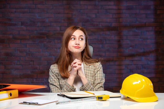 front view female engineer sitting behind her working place in construction site job agenda builder contractor business success corporate property