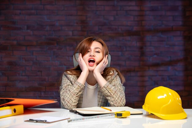 front view female engineer sitting behind her working place in construction site job agenda business corporate builder contractor success plan