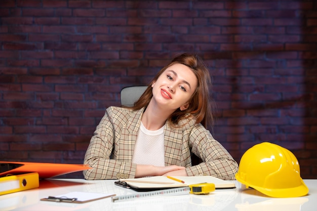 front view female engineer sitting behind her working place in construction site job agenda business corporate contractor property success plan builder