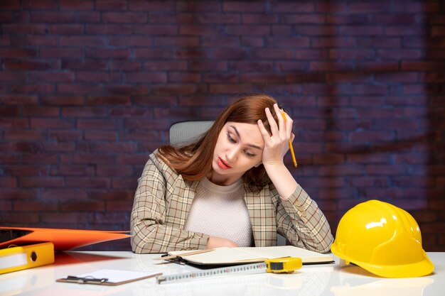 front view female engineer sitting behind her working place in construction site job agenda plan property business contractor builder corporate