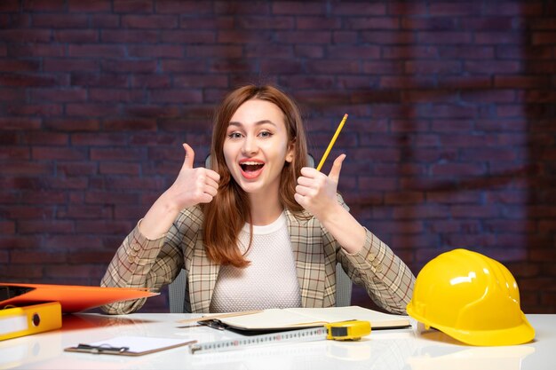 front view female engineer sitting behind her working place in construction site job agenda property contractor builder corporate plan business success