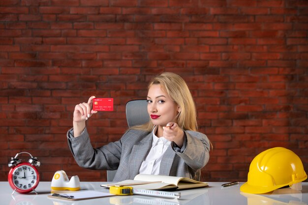 Front view female engineer sitting behind her working place