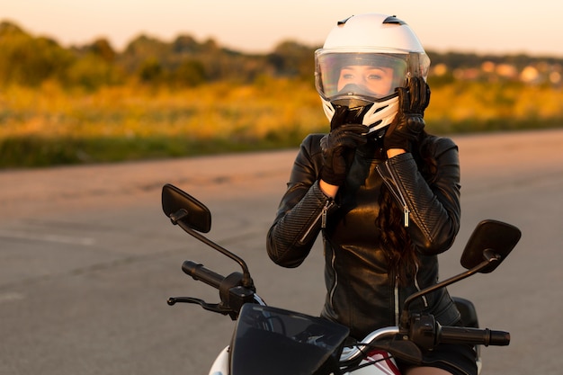 Foto vista frontale del motociclista femminile con il casco