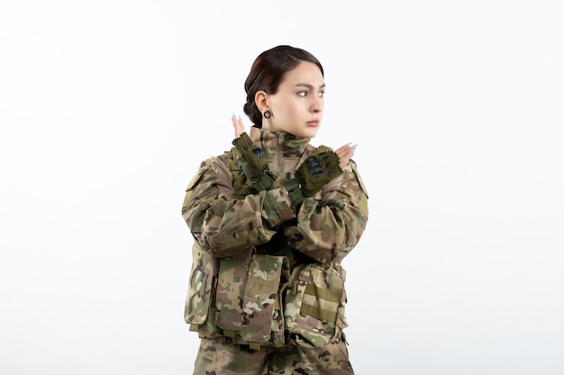 흰 벽에 위장에 여성 군인의 전면보기