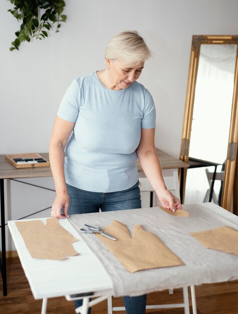 Front view of female tailor in the studio with fabric