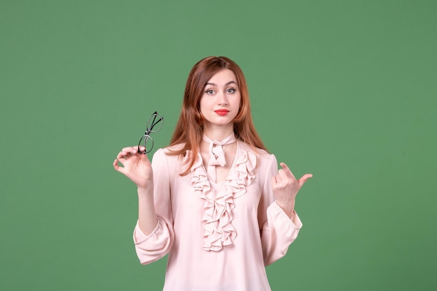 Front view female teacher in pink blouse on green background college color work book students school job woman library lesson young