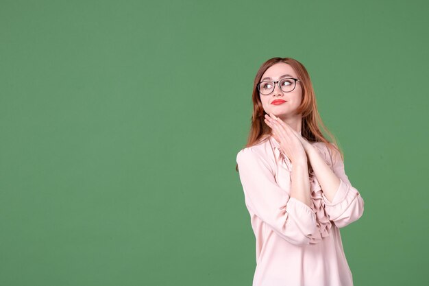 Front view female teacher in pink blouse on green background school color book library college student young lesson work woman job