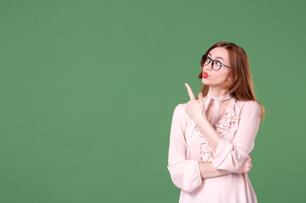 Front view female teacher in pink blouse on green background school color library college job woman student book lesson work